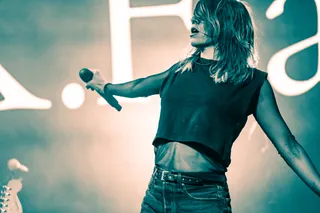 Woman singing on stage with microphone at concert