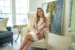 Woman sitting in chic living room with professional outfit